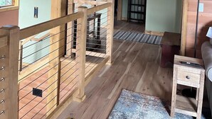 Ein Holzinnenraum mit einer Treppe, einem kleinen Tisch und einem Sofa.