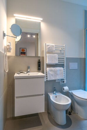 Superior eenpersoonskamer | Badkamer | Een douche, handdoeken, toiletpapier