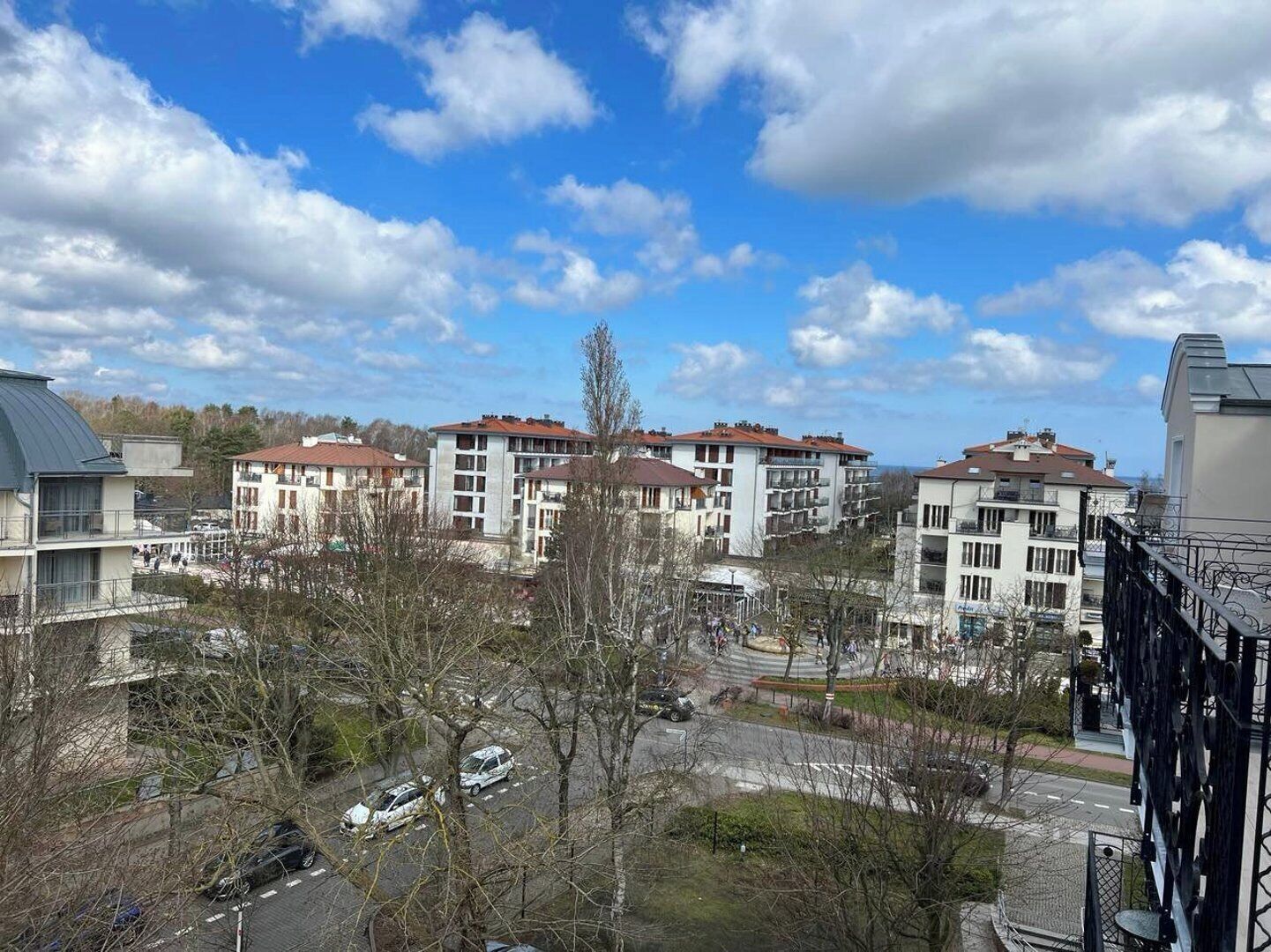 Ein Wohngebiet mit mehrstöckigen Gebäuden, einem Parkplatz und blauem Himmel.