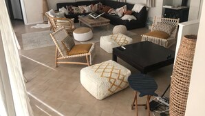 A living room with a sofa, chairs, ottomans, a coffee table, and a fireplace. - Charming Villa Son Parc (Son Parc)
