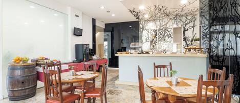 A modern dining area with wooden tables and chairs, a central island with a bar, and a decorative tree sculpture.
