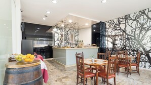 A modern kitchen with a central island, wooden chairs, and a marble floor. - Alda Camiño Inglés (Ordes)