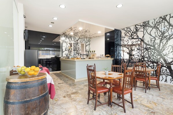 Cocina moderna con una isla central, sillas de madera y piso de mármol.