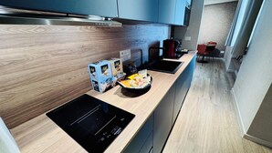 Eine moderne Küche mit integriertem Induktionskochfeld, Holzschränken und einer eleganten Arbeitsplatte.