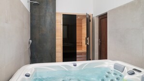 A modern bathroom with a hot tub, a shower, and a wooden sauna door. - Villa Terra & Aria Dalmatica pool sauna&jacuzzi (Sikovo)