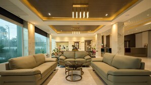 A modern living room with sofas, a coffee table, and a fireplace. - Benjaphorn Grandview Hotel (Songkhla)