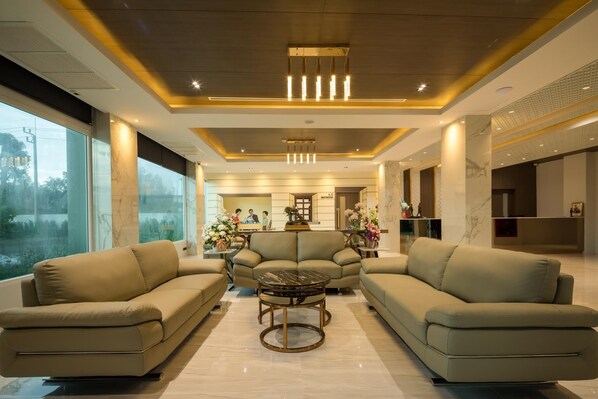 A modern living room with sofas, a coffee table, and a fireplace. - Benjaphorn Grandview Hotel (Songkhla)