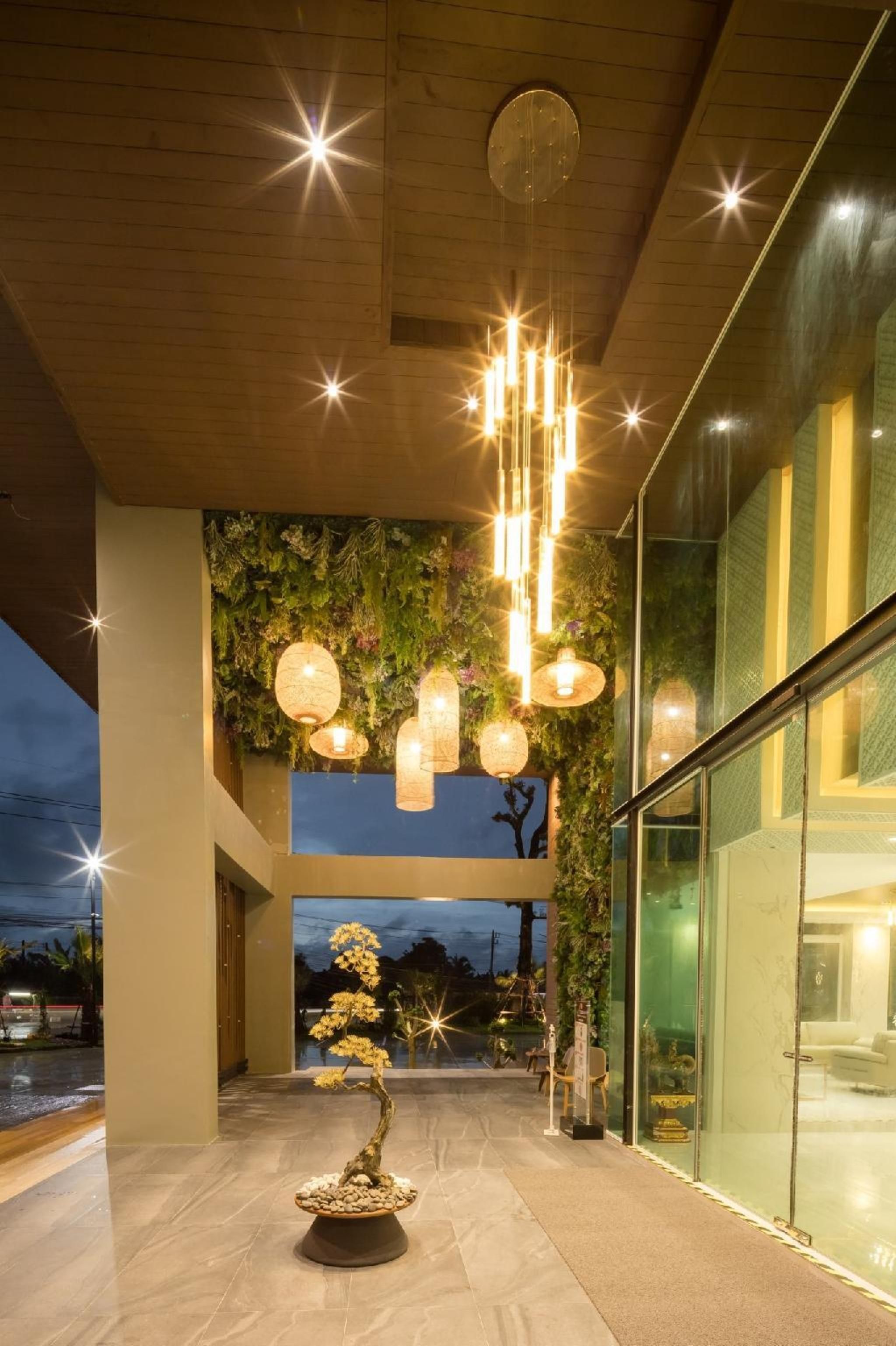 A modern building with a glass facade, a central staircase, and a bonsai tree.