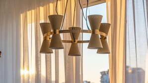 A dining area with a glass table, wooden chairs, and a chandelier. - Scandinavian Premium Atelier - Spacious Comfort (København)