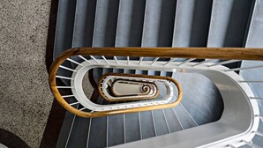 Una escalera de caracol con barandilla de madera y balaustres blancos.