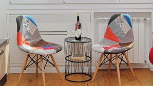 Two modern chairs with geometric patterns, a small round table with a bottle and glasses, and a radiator in a room with wooden flooring. - Modern Apartment in Rome 200 meters from Metro Line A


 (Roma)