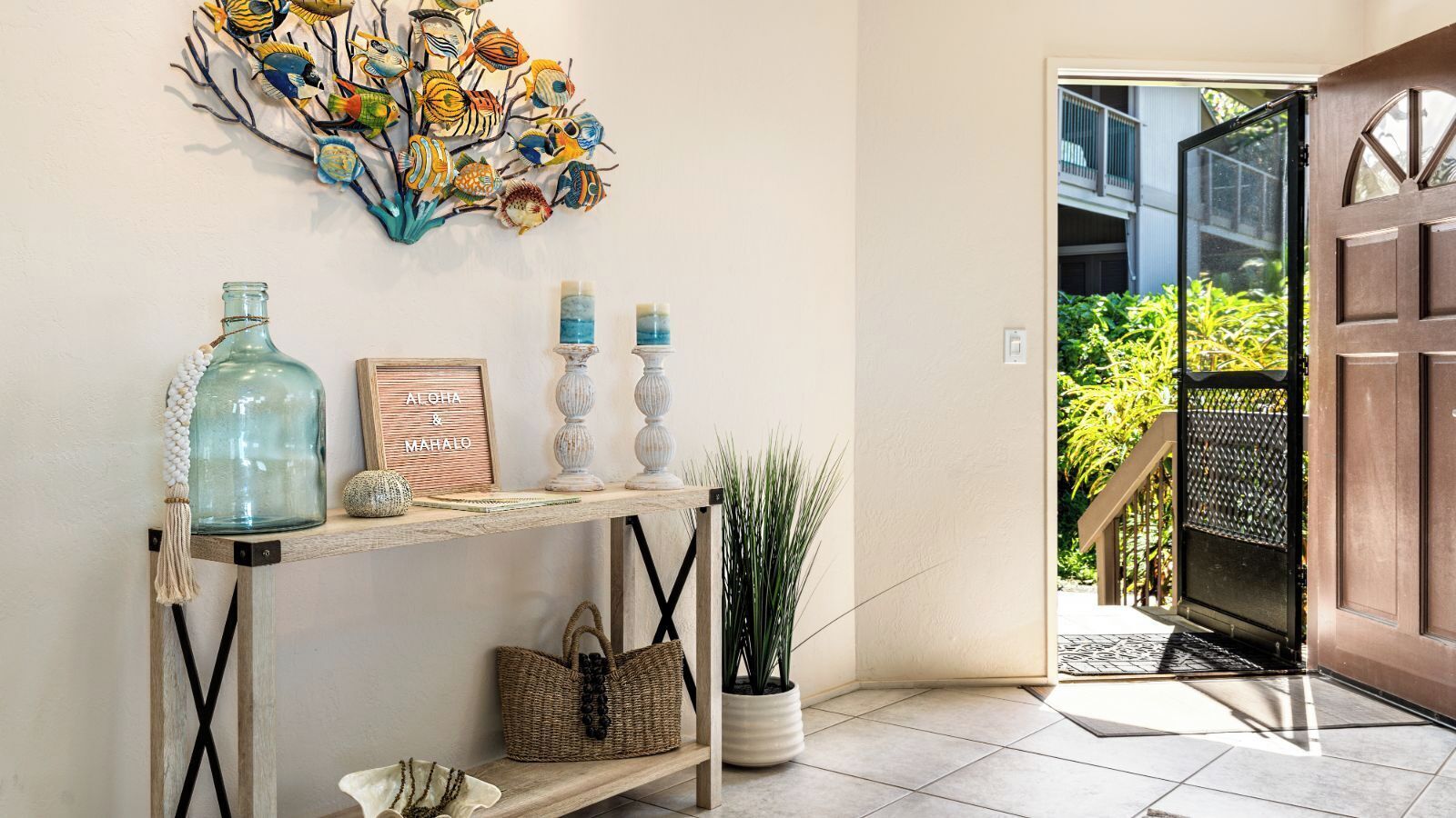 A wooden console table with decorative items, a wall art piece, and a door leading to an outdoor area.