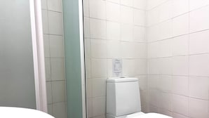A bathroom with a toilet, a trash bin, and a sign on the wall. - Phaedrus Living: Hoopoe Residencies 105 (Nicosia)