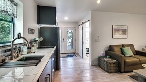 Una cocina moderna con un lavaplatos integrado y una zona de comedor con un sofá de cuero marrón.