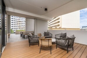 Uma varanda com móveis de vime e vista para um edifício moderno.