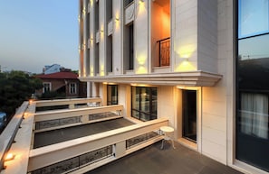 Un edificio moderno con balcón, ventanas amplias y una escalera.