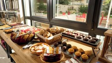 Una mesa de buffet con diversos productos de pastelería y repostería.
