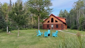A log cabin with a red roof surrounded by a grassy yard and trees. - Up North Retreat near Lake Superior (Port Wing)
