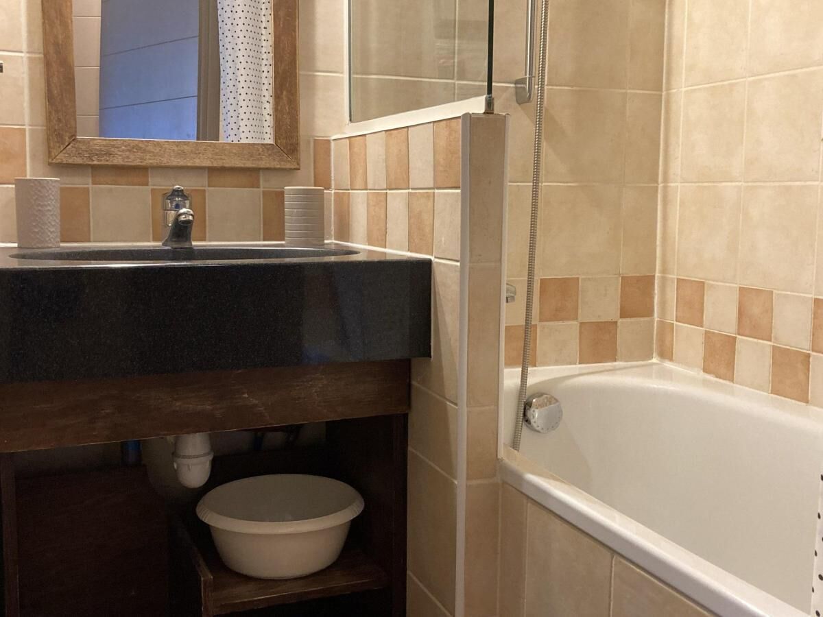 Une salle de bain avec un lavabo, un miroir et une baignoire.