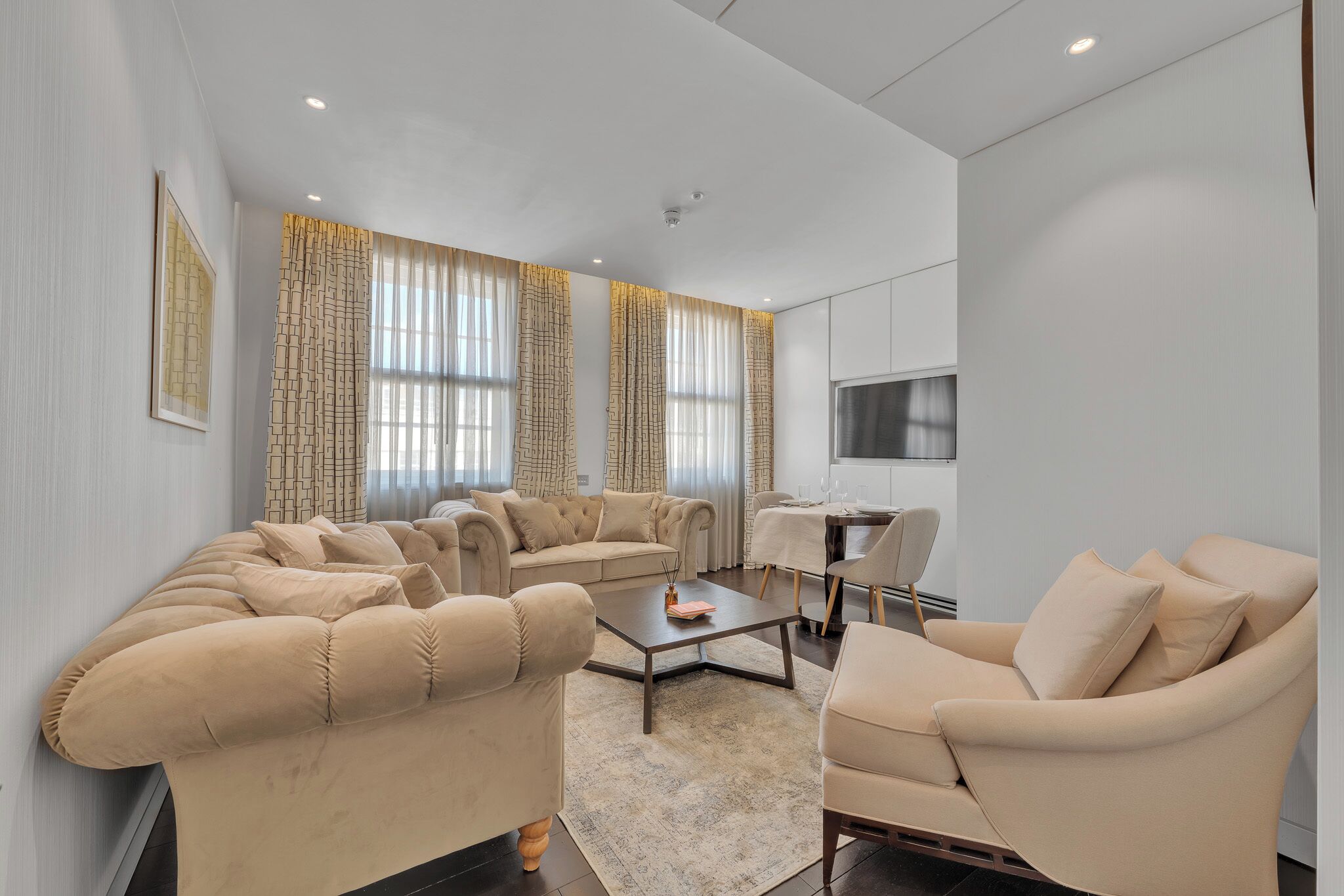 Uma sala de estar moderna com um sofá seccional, uma mesa de centro e um espaço de jantar com mesa e cadeiras.