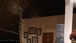 A dining area with tables set for meals, a water dispenser, and framed pictures on the wall. - Hotel Kraken (Tola)