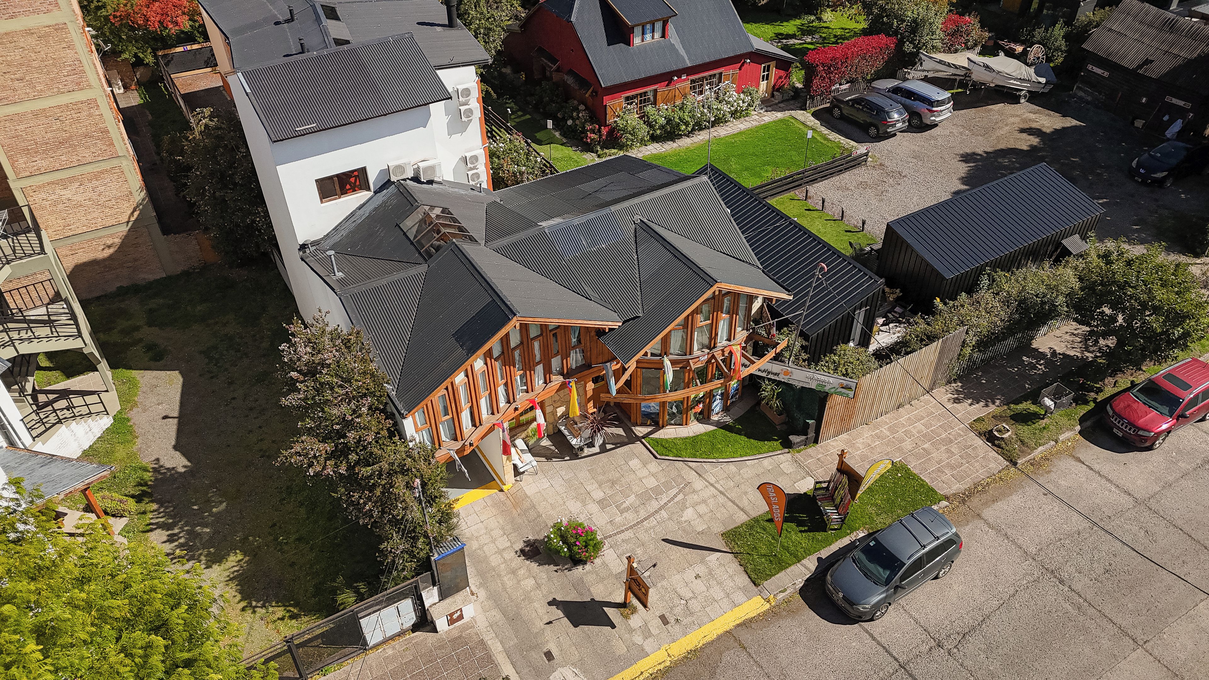 A residential building with a sloped roof, a covered porch, and a small garden area.