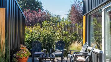 A deck with outdoor furniture, a potted plant, and a wooden fence.