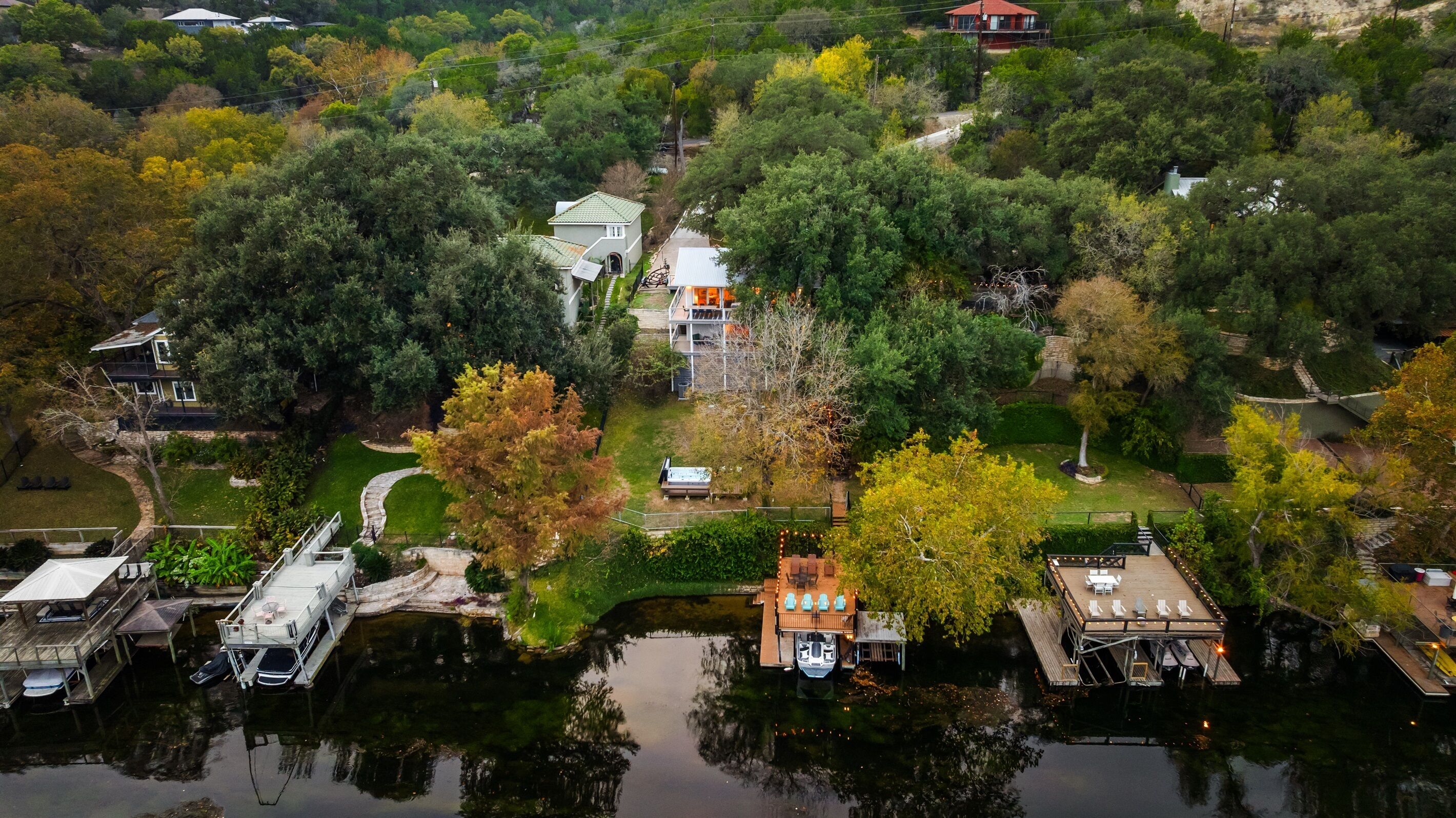 An aerial view of a property with a dock, a small boat, and a gazebo.