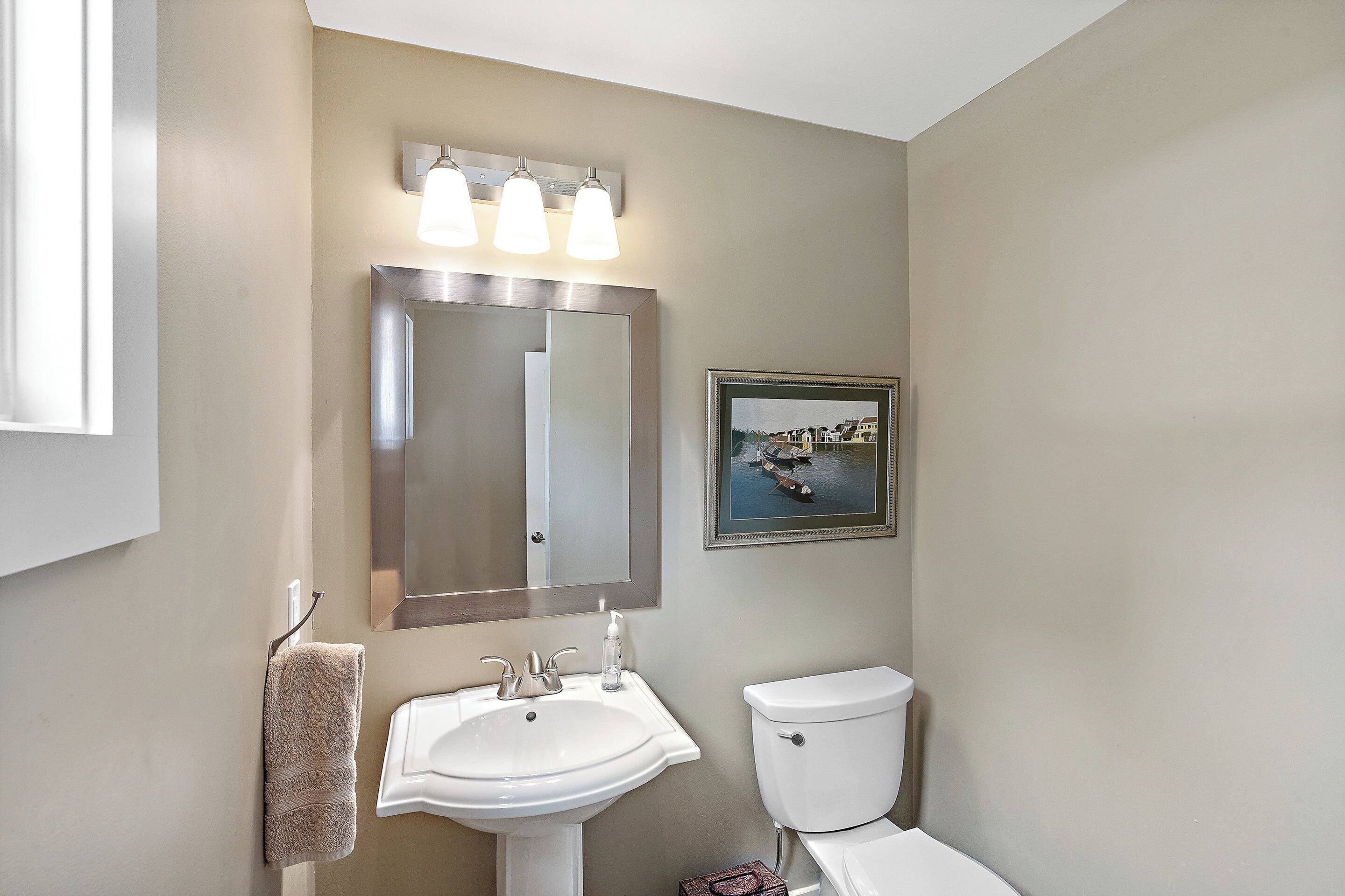 A bathroom with a sink, mirror, and toilet.