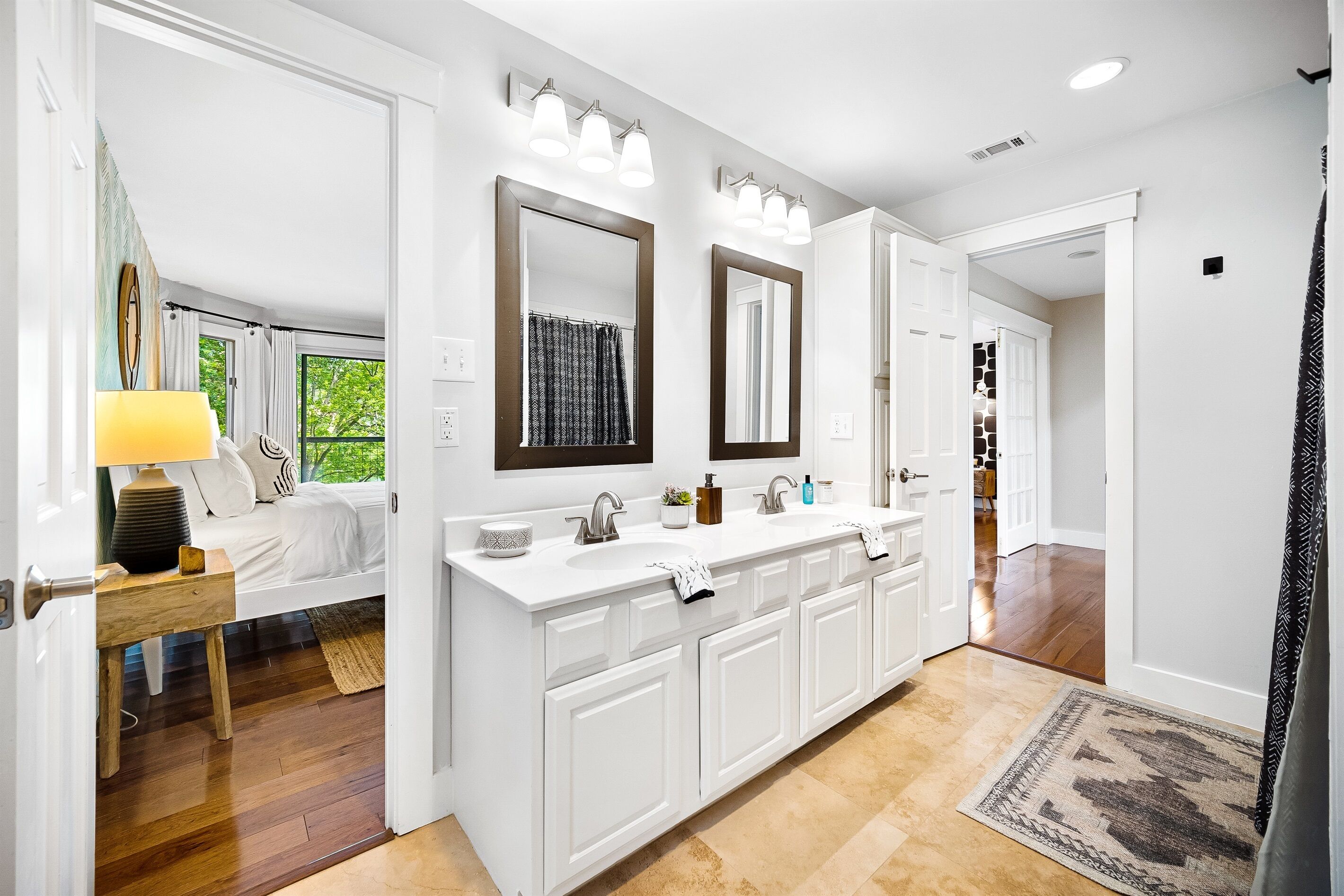 A modern bathroom with a large vanity, double sinks, and a mirror above each sink.