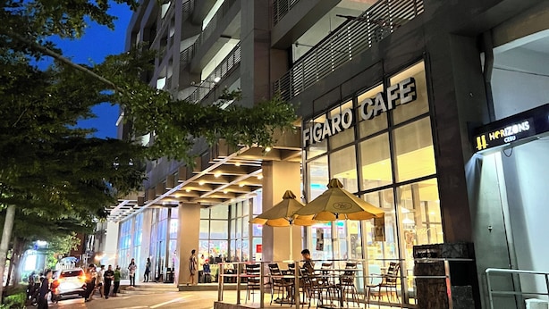 Un edificio de varios pisos con una cafetería llamada "Figaro Cafe" en la planta baja.