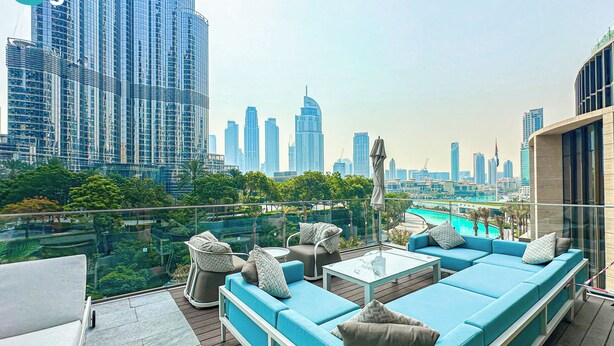 A rooftop lounge with a city view, including high-rise buildings and a swimming pool. - HiGuests - Address Opera Residences (Dubai)
