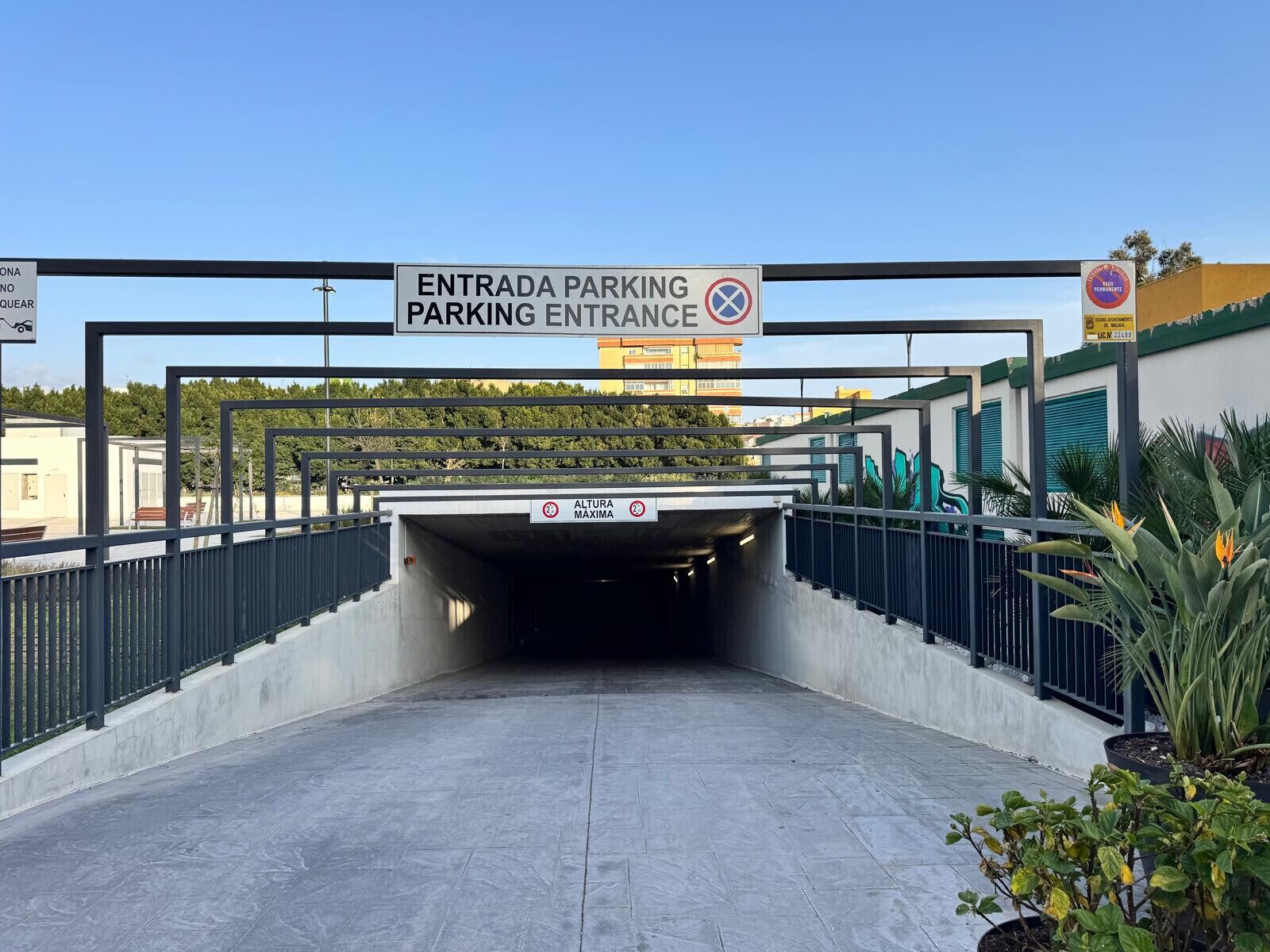 A parking entrance with a sign indicating height restrictions.