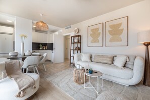 A modern living room with a sofa, chairs, a coffee table, and artwork on the wall.