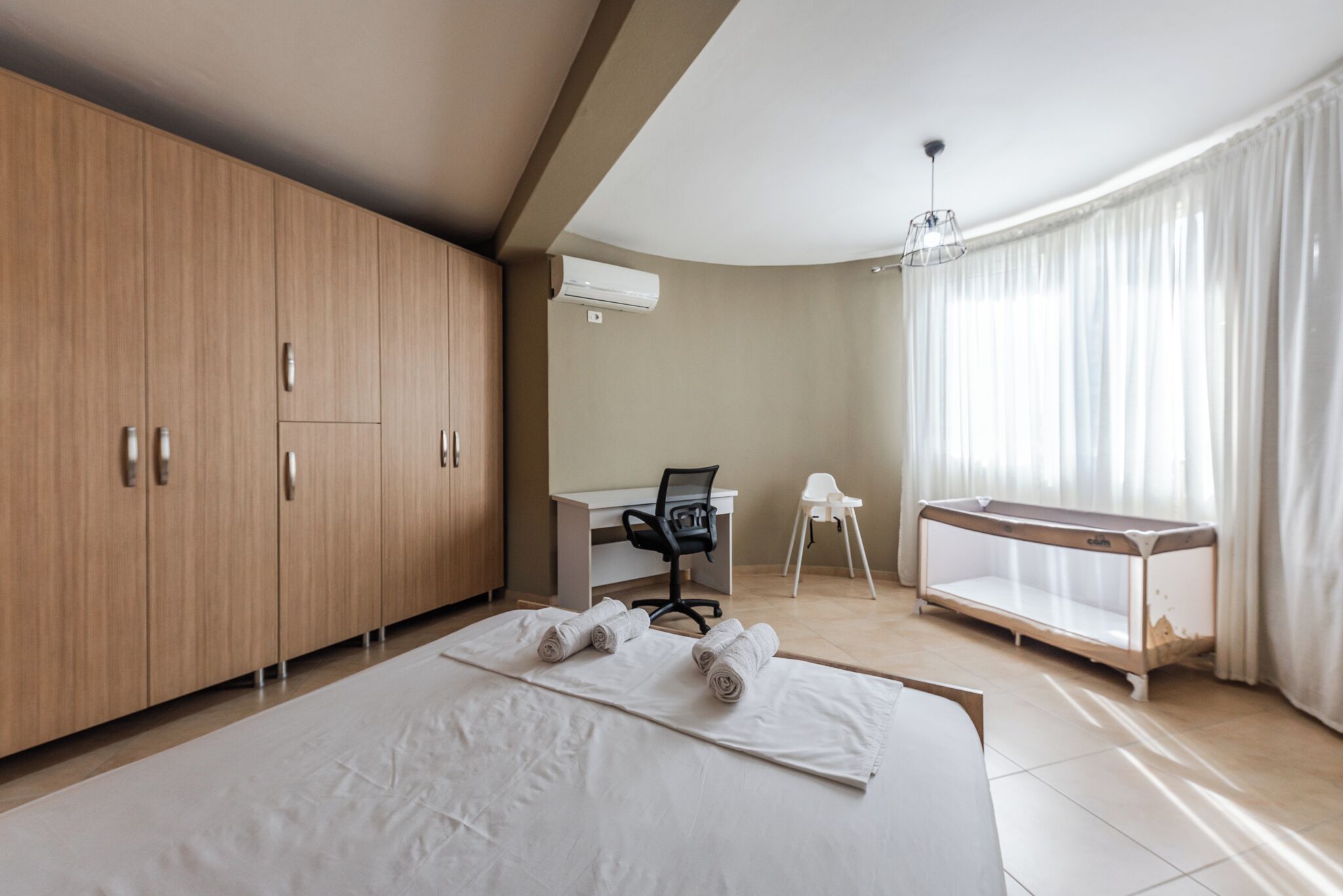 Una camera da letto con un letto grande, una scrivania, una sedia e un tavolino.