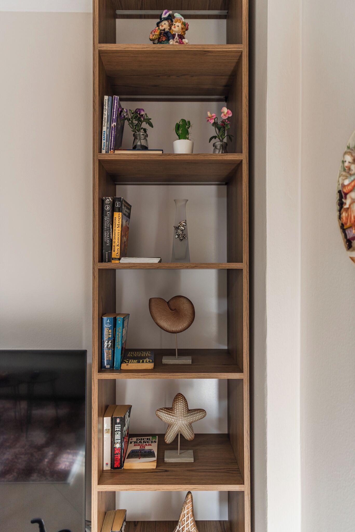 Een houten boekenkast met diverse decoratieve items en boeken.