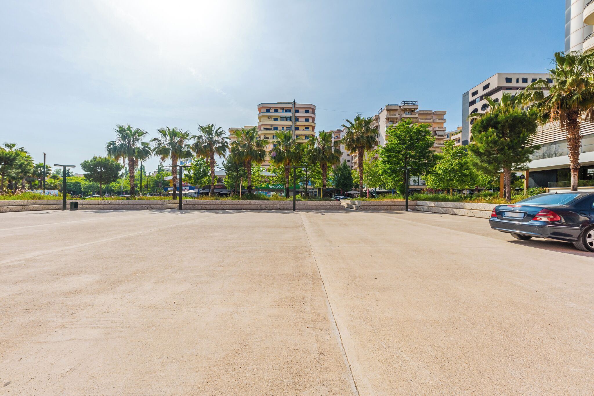 Amplio espacio al aire libre con palmeras y un estacionamiento.