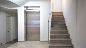 A modern interior with a staircase, a door, and a light fixture. - Habitat Apartments Teatre 11 (Barcelona)