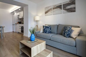 Un salon moderne avec un canapé gris, une table basse et un vase bleu contenant des plantes.