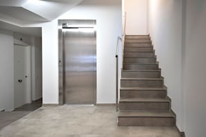 Un intérieur moderne avec un escalier menant à un ascenseur.