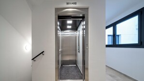 An elevator with a sign reading "SEGUNDO" leading to a modern interior with a tiled floor and a handrail on the left. - Habitat Apartments Teatre 22 (Barcelona)