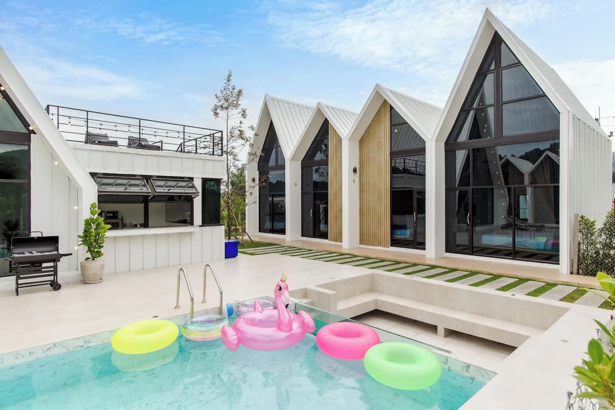 A modern building with a swimming pool, a barbecue area, and a hot tub.