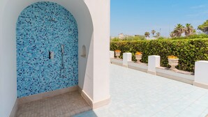 A tiled pool area with a blue mosaic wall, a clear sky, and a hedge in the background. - Villa Giusy 2 by BarbarHouse (Mancaversa)
