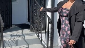 A person standing at the entrance of a building with a black metal gate and a white wall. - Fabulous entire 2-bedroom house with onsite washer/dryer in Richmond near Bart. (Richmond)