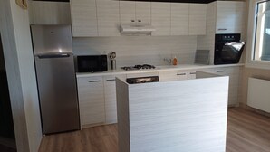 A modern kitchen with a stainless steel refrigerator, a microwave, a gas stove, and a dishwasher. - Comfortable villa with pool in the countryside (Foissiat)