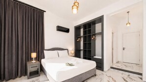 Ein modernes Schlafzimmer mit einem großen Bett, einem Einbauschrank, einem Nachttisch und einem Beistelltisch.