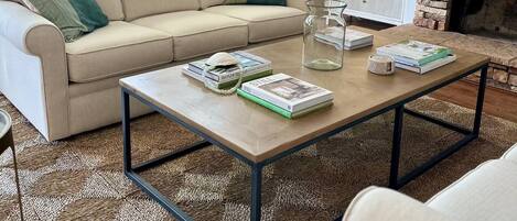 Un salon moderne avec un canapé beige, une table basse et une cheminée.