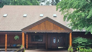 A wooden building with a pitched roof, a front porch, and a door with a circular window. - The Springbrook  Inn - Forrest View Room (Hot Tub) (Denton Township)