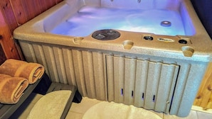 A hot tub with a control panel, towels, and a wooden interior. - The Springbrook  Inn - Forrest View Room (Hot Tub) (Denton Township)