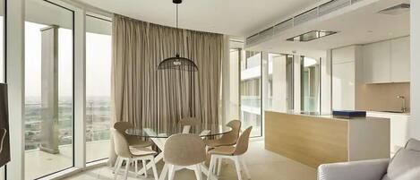 A modern living room with a dining area, a sofa, and a kitchen.